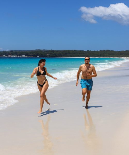 Couple courant sur la plage d'Hyams Beach