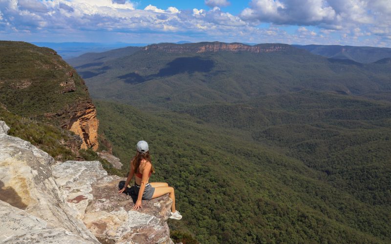 Femme assise sur un rocher avec la vue dégagé sur les blue mountains
